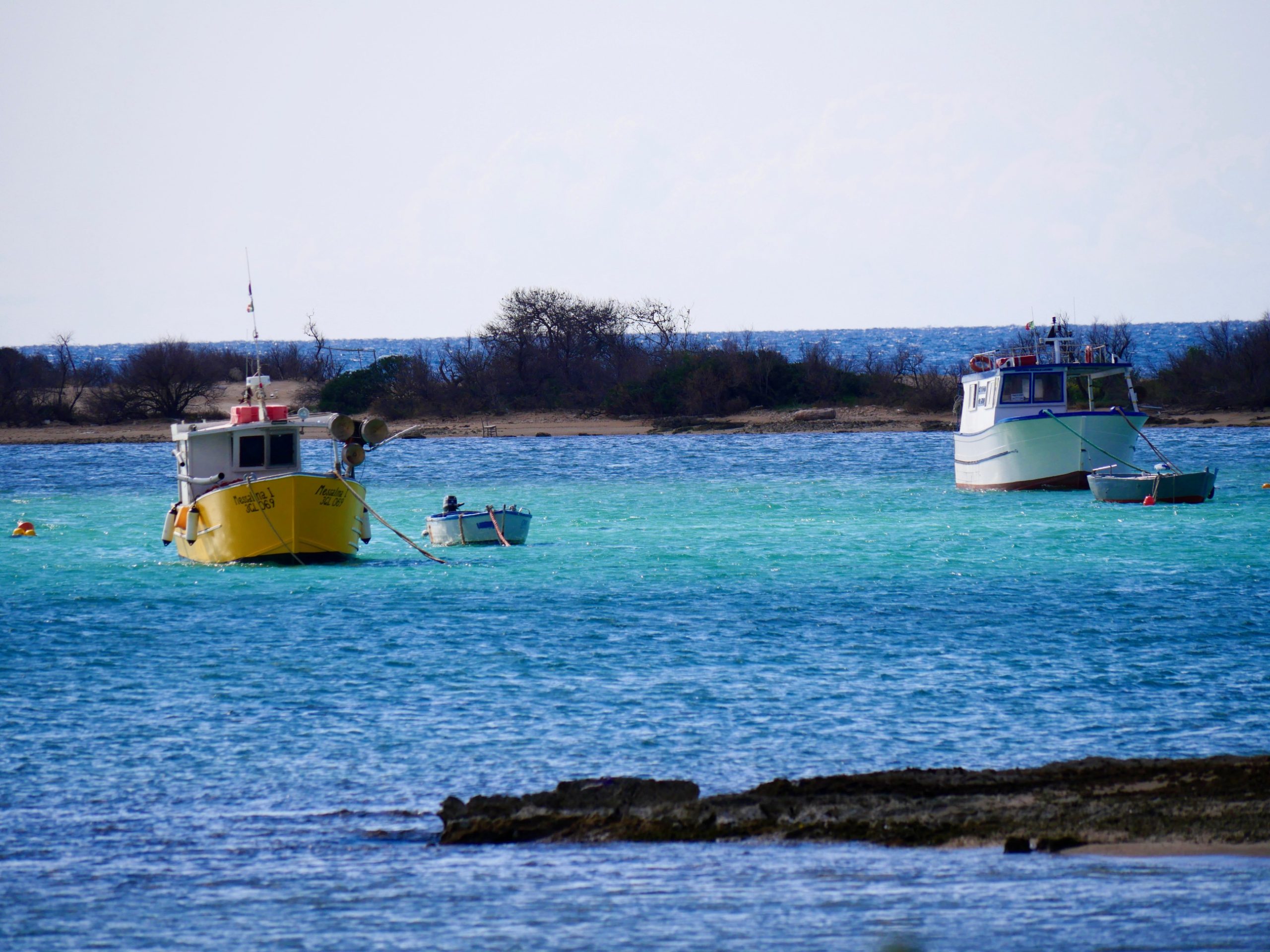 Blauwe zee met bootjes bij Puglia
