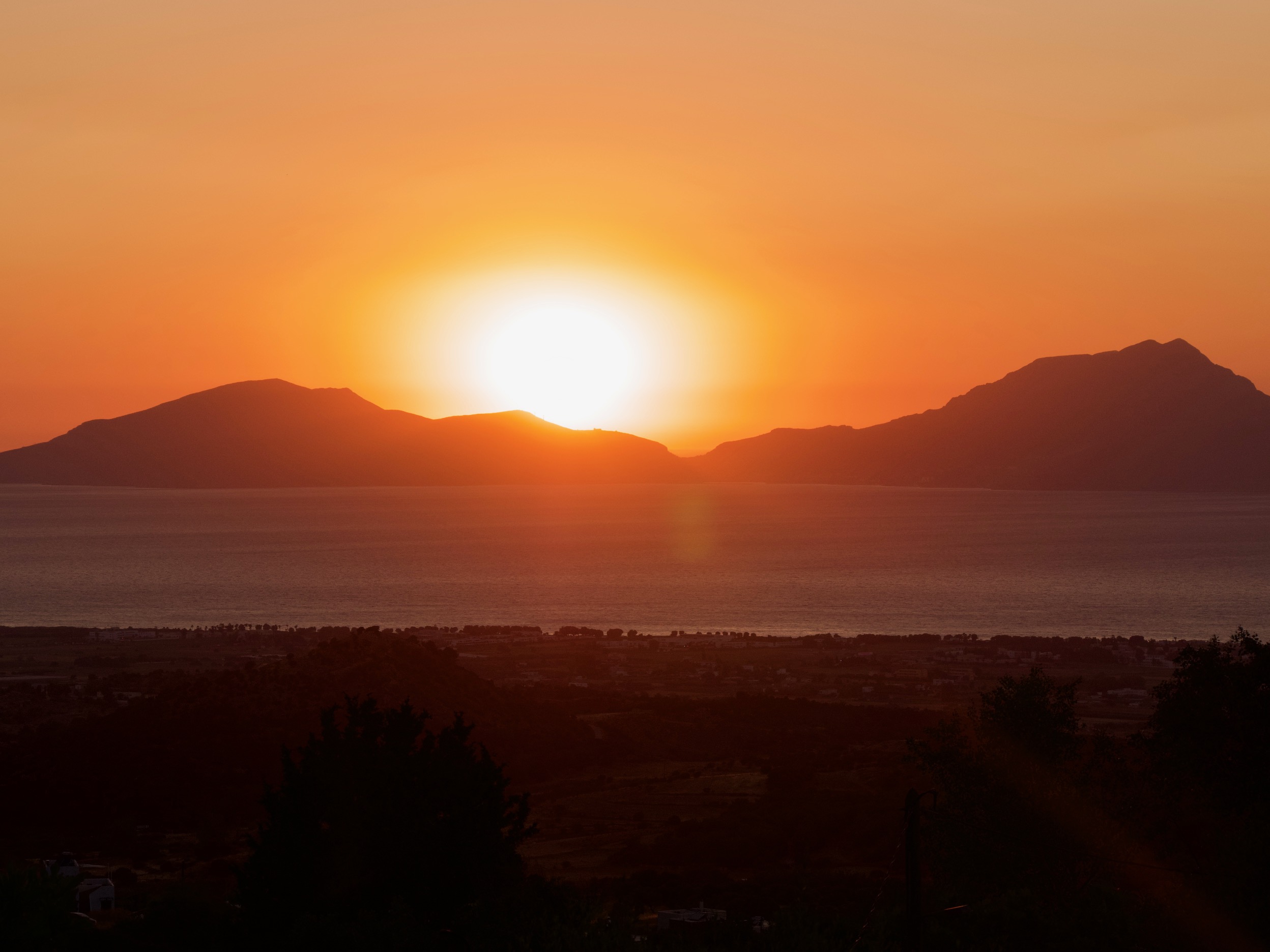 de zon zakt bijna achter de bergen in Zia op Kos