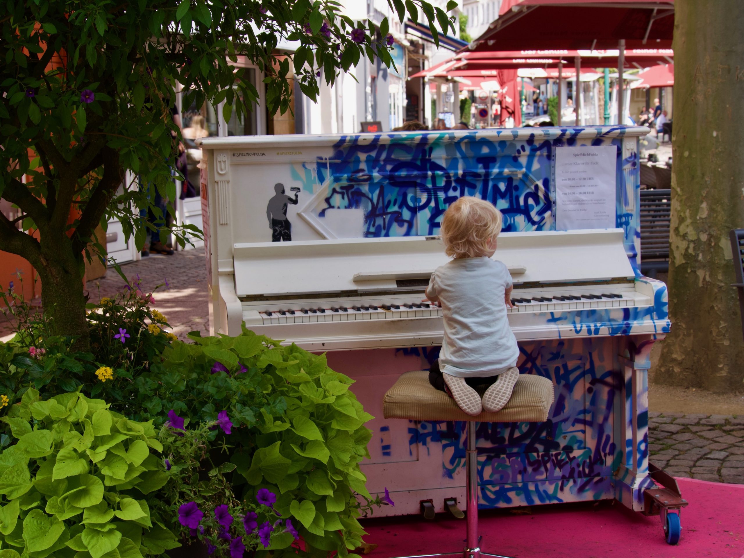 jongen speelt piano op een openbare piano in Fulda