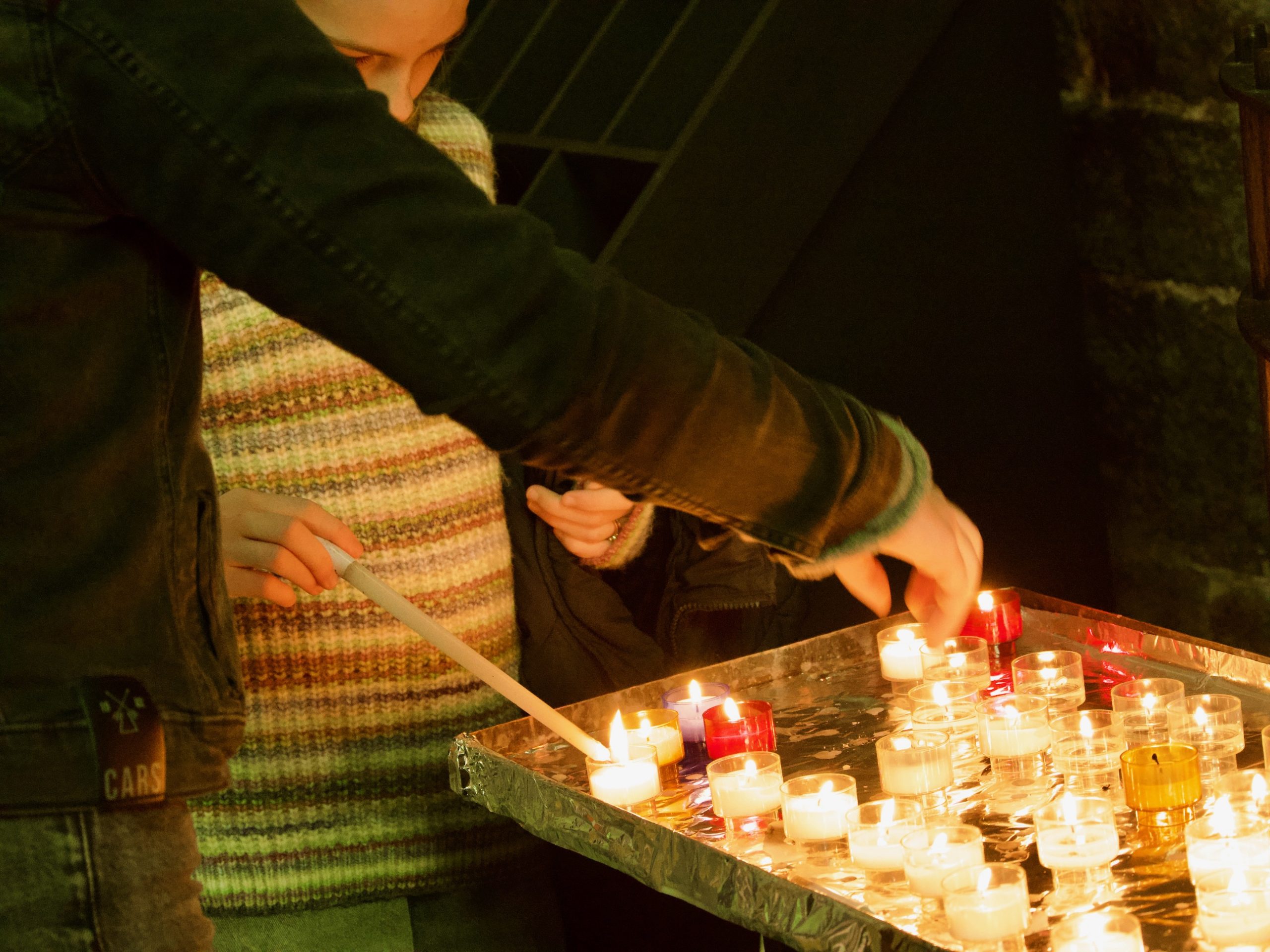 Kinderen steken een kaarsje aan in de onze-lieve-vrouwen kerk van Dinant
