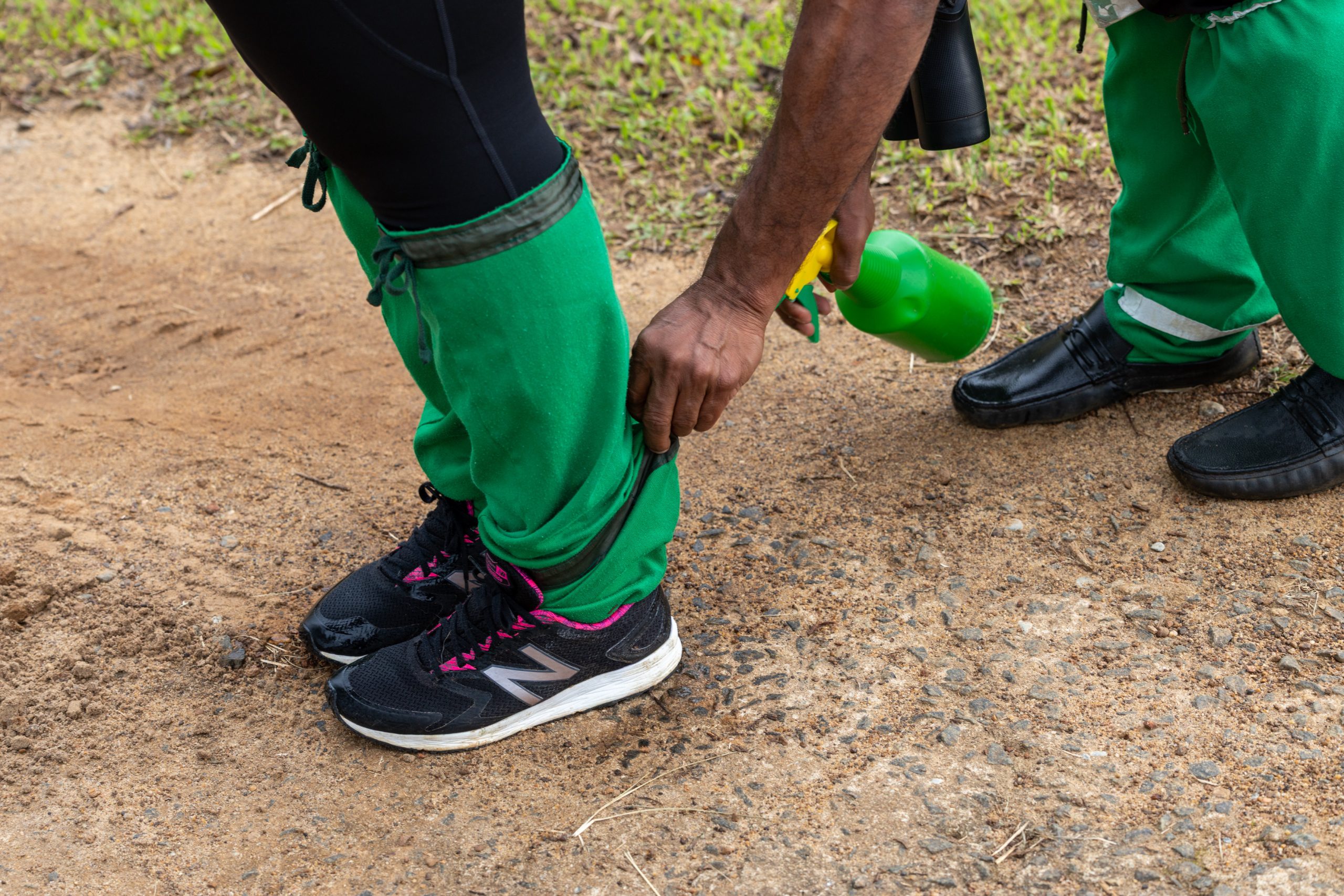 De gids spuit de schoenen in met Dettol tegen de bloedzuigers