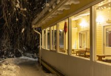 Hotel Tuhannen Tarinan Talo in de avond en sneeuw