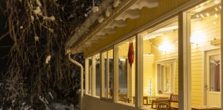 Hotel Tuhannen Tarinan Talo in de avond en sneeuw