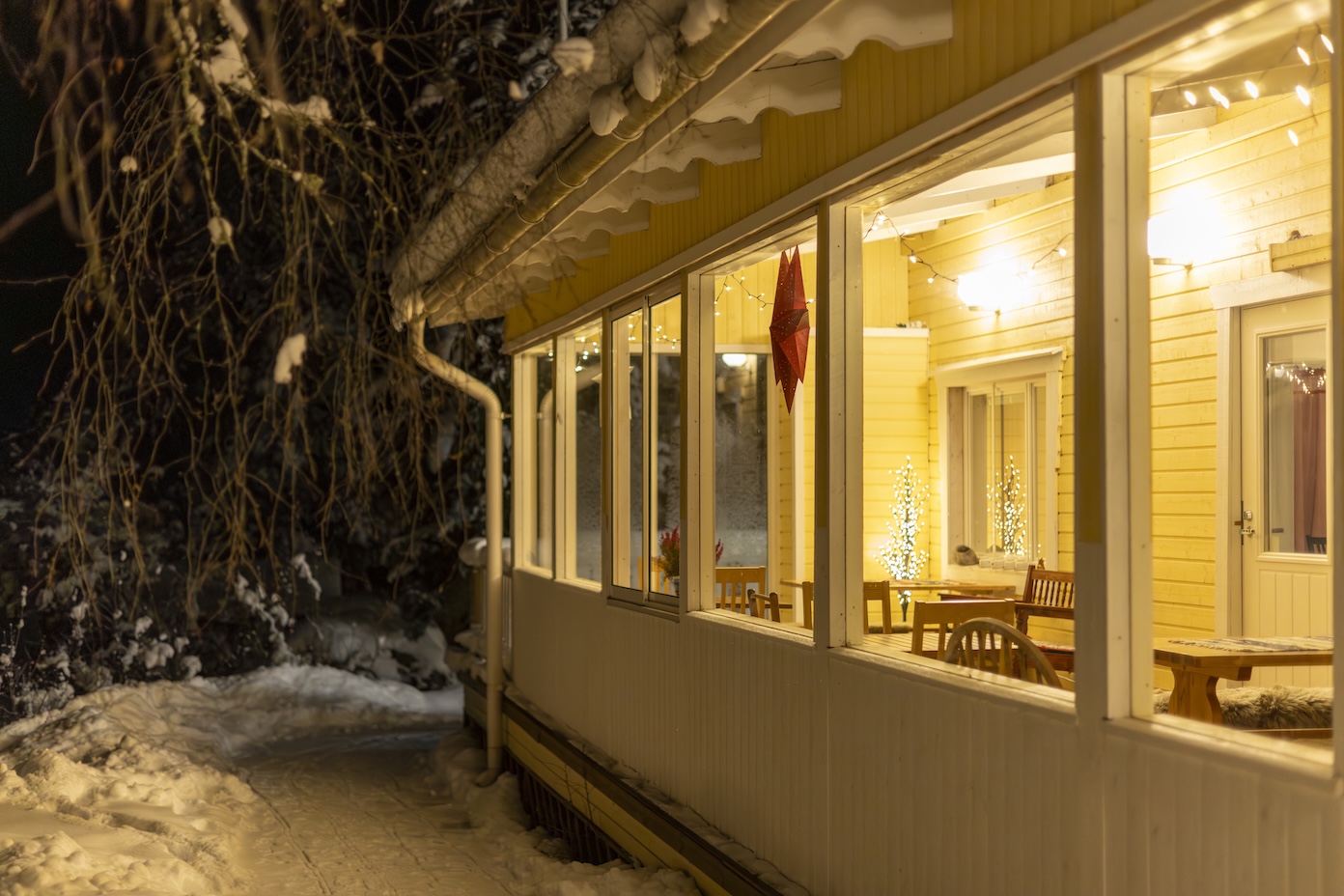 Hotel Tuhannen Tarinan Talo in de avond en sneeuw