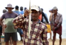 Vissers in Sri Lanka: een eeuwenoude traditie langs de westkust Visser in Sri Lanka met een vis